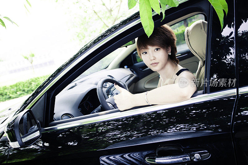 pretty girl sitting in her new black car